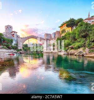 Fantastische Skyline von Mostar mit der Mostar Brücke, Häusern und Minaretten, bei Sonnenuntergang. Lage: Mostar, Altstadt, Bosnien und Herzegowina, Europa Stockfoto