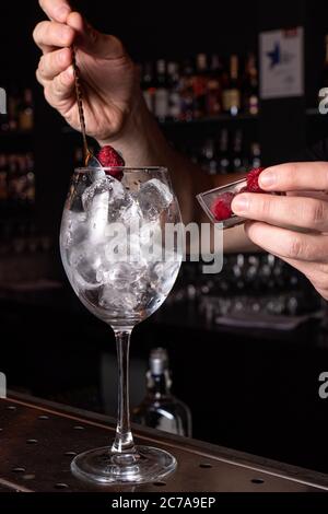 Der Barkeeper bereitet einen Cocktail in der Restaurantbar zu. Der Prozess des Gießen von Alkohol in ein Glas. Stockfoto