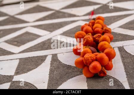 Geerntete Tomaten trocknen an einer Wand mit traditionellen Mustern im Dorf Pirgi auf der griechischen Insel Chios. Stockfoto