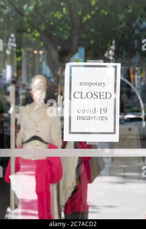 Closeed Hinweis wegen Coronavirus Maßnahmen auf Fenster eines Boutique-Shop. Stockfoto