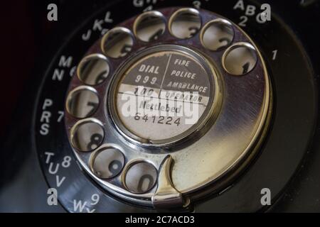 Altes britisches Vintage-Telefon aus Metall mit Federladung und rotierendem Ziffernblatt auf schwarzem GPO-Bakelit-Telefon mit Nettlebed 641224-Nummer in Oxfordshire, Großbritannien Stockfoto