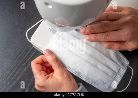 Gesichtsmaske Nähen zu Hause gegen Coronavirus. Stockfoto