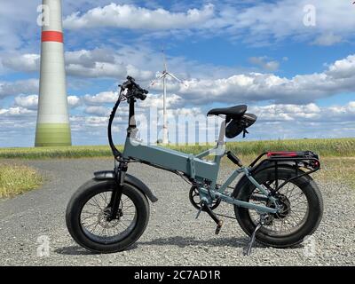 Modernes elektrisches Fatbike mit Windturbine im Hintergrund Stockfoto
