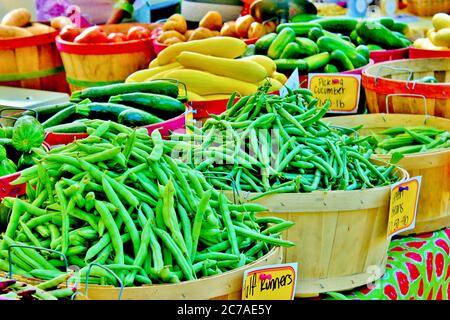Frische grüne Bohnen, Kürbis und anderes Gemüse zum Verkauf auf einem Bauernmarkt im Freien Stockfoto