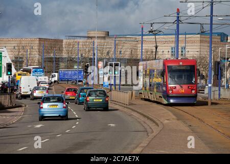 Midland Metro Ansaldo T69 Tram 04 bei der Royal, Wolverhampton vorbei Verkehr auf der zweispurigen Straße Stockfoto