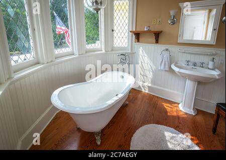 Badewanne mit Clawfoot-Füßen und Standwaschbecken im Vintage-Badezimmer Stockfoto