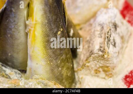 Stücke von Navaga Fisch in Teig, zum Braten in einer Pfanne vorbereitet. Stockfoto