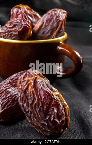 Große luxuriöse Trockendatierung in Schüsseln auf der dunklen Oberfläche, Kurma ramadan kareem Concept, aus der Nähe. Stockfoto