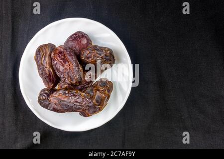 Große luxuriöse Trockendatierung in Schüsseln auf der dunklen Oberfläche, Kurma ramadan kareem Concept, aus der Nähe. Stockfoto