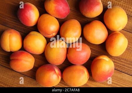 Reife Aprikosen auf einem braunen Holztisch. Draufsicht. Nahaufnahme Stockfoto