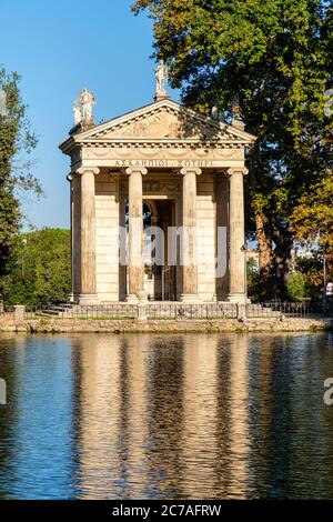 Antike römische Gebäude, ionischer Tempel des Asklepius (Aesculapius) reflektiert auf Laguetto di Villa Borghese, Gärten der Villa Borghese, Rom, Italien Stockfoto