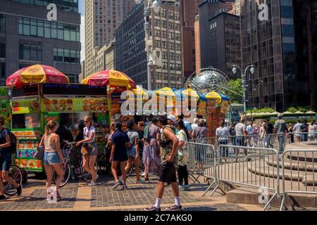 New York, NY / USA - 24. Juli 2019: Columbus Circle Verkäufer mit Globe Statue im Hintergrund in der Nähe des Central Park Stockfoto