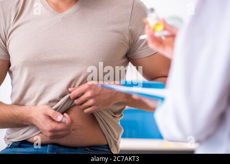 Männlicher Diabetiker, der einen jungen Arzt besucht Stockfoto