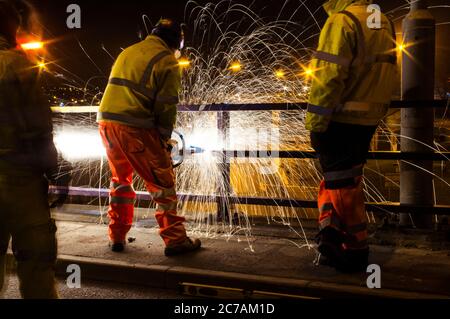 Straßenpersonal in der Nachtschicht, das an der Brücke arbeitet Stockfoto