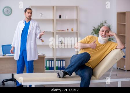 Alter Hals verletzten Mann besucht jungen Arzt Stockfoto