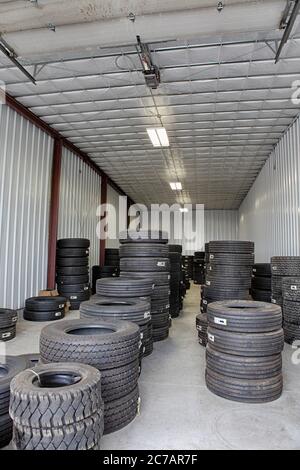 Neue und gebrauchte Reifen in einem kleinen Lager gestapelt, warten auf die Installation auf Lastwagen. Stockfoto