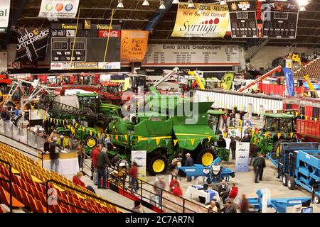 Bauern, die sich bewegen und sich die landwirtschaftlichen Geräte angun, die während eines landwirtschaftlichen Seminars auf einer Messe ausgestellt und verkauft werden. Stockfoto