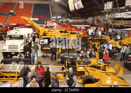 Bauern, die sich bewegen und sich die landwirtschaftlichen Geräte angun, die während eines landwirtschaftlichen Seminars auf einer Messe ausgestellt und verkauft werden. Stockfoto