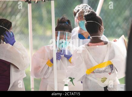 Austin, TX USA 15. Juli 2020:Medizinische Techniker, die für Austin Public Health arbeiten, ziehen Schutzkleidung (PSA) an und führen kostenlose COVID-19-Vorführungen in einem öffentlichen Park durch. Texas hat einen enormen Anstieg bei Coronavirus-Fällen mit fast 300,000 Fällen gesehen, die zu mindestens 3,432 Todesfällen geführt haben. Kredit: Bob Daemmrich/Alamy Live Nachrichten Stockfoto