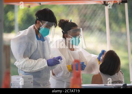 Austin, TX USA 15. Juli 2020:Medizinische Techniker, die für Austin Public Health arbeiten, ziehen Schutzkleidung (PSA) an und führen kostenlose COVID-19-Vorführungen in einem öffentlichen Park durch. Texas hat einen enormen Anstieg bei Coronavirus-Fällen mit fast 300,000 Fällen gesehen, die zu mindestens 3,432 Todesfällen geführt haben. Kredit: Bob Daemmrich/Alamy Live Nachrichten Stockfoto