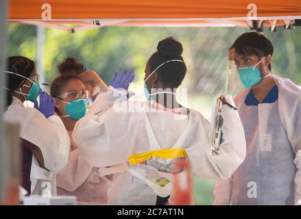 Austin, TX USA 15. Juli 2020:Medizinische Techniker, die für Austin Public Health arbeiten, ziehen Schutzkleidung (PSA) an und führen kostenlose COVID-19-Vorführungen in einem öffentlichen Park durch. Texas hat einen enormen Anstieg bei Coronavirus-Fällen mit fast 300,000 Fällen gesehen, die zu mindestens 3,432 Todesfällen geführt haben. Kredit: Bob Daemmrich/Alamy Live Nachrichten Stockfoto