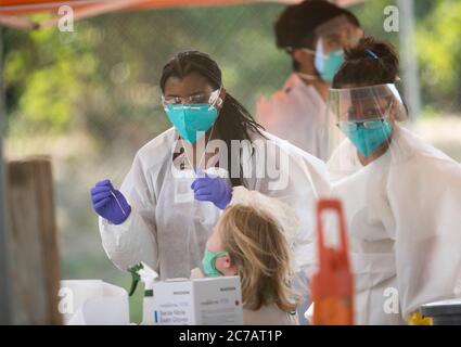 Austin, TX USA 15. Juli 2020:Medizinische Techniker, die für Austin Public Health arbeiten, ziehen Schutzkleidung (PSA) an und führen kostenlose COVID-19-Vorführungen in einem öffentlichen Park durch. Texas hat einen enormen Anstieg bei Coronavirus-Fällen mit fast 300,000 Fällen gesehen, die zu mindestens 3,432 Todesfällen geführt haben. Kredit: Bob Daemmrich/Alamy Live Nachrichten Stockfoto