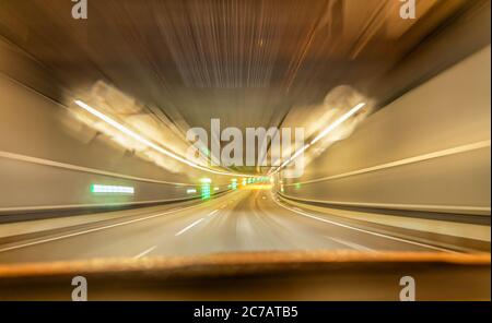 Schnelle Fahrt mit dem Auto durch einen unterirdischen Tunnel - Blick auf die Straße. Stockfoto