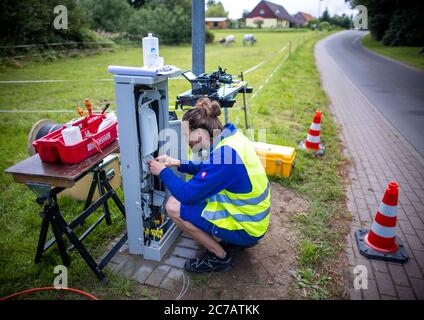 15. Juli 2020, Mecklenburg-Vorpommern, Bentin: Lichtleitertechniker Lars Romann bereitet ein Lichtleiterkabel für die Installation von Hausanschlüssen auf einer Baustelle für den Breitband-Internetausbau vor. Die Firma WEMACOM verlegt derzeit Glasfaserverbindungen im Landkreis Nordwest-Mecklenburg. Bisher wurden rund 5,500 Hausanschlüsse für den Anschluss an das schnelle Glasfasernetz vorbereitet. Mecklenburg-Vorpommern erhält rund 850 Millionen Euro aus dem Bundesprogramm für den Breitbandausbau in unterversorgten ländlichen Regionen. Foto: Jens Büttner/dpa-Ze Stockfoto