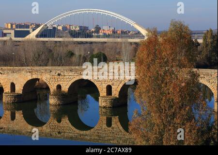 Merida, Badajoz, Extremadura, Spanien. Die römische Brücke, die auf dem Guadiana Fluss reflektiert. Moderne Lusitania Brücke im Hintergrund. UNESCO-Weltkulturerbe. Stockfoto