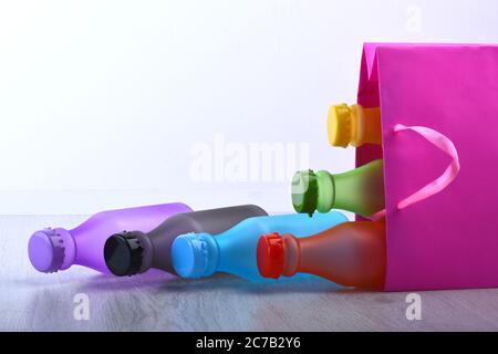 Energy Drinks Behälter mit verschiedenen Geschmacksrichtungen. Shopping und farbige Getränke Konzept. Set von Flaschen in verschiedenen Farben innerhalb rosa Paket. Einkaufstasche mit bunten Softdrinks auf weißem Hintergrund Stockfoto