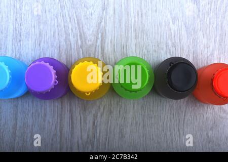 Set Flaschen in verschiedenen Farben. Energy Drinks Behälter mit verschiedenen Geschmacksrichtungen. Reihe von bunten alkoholfreien Getränken auf hellem Holzhintergrund. Regenbogen Komposition und Getränkekonzept. Stockfoto