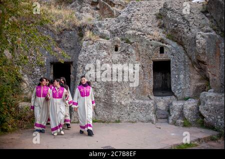 Ein örtlicher Frauenchor in Geghard, einem mittelalterlichen Kloster, das teilweise aus dem benachbarten Berg in der Provinz Kotayk bei Jerewan, Armenien, herausgeschnitten wurde. Stockfoto