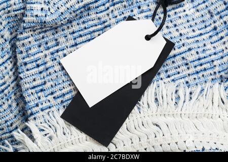 Kleidung Tag, Etikett leer Mockup auf einer Kleidung, um Ihr Design zu platzieren. Mode, Menschen und Shopping-Konzept - schließen Preisschild von Kleidungsstück Stockfoto