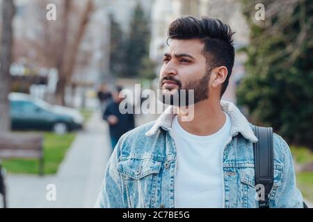Stilvoll gekleideter indischer Bärtiger geht die Straße hinunter. Stockfoto