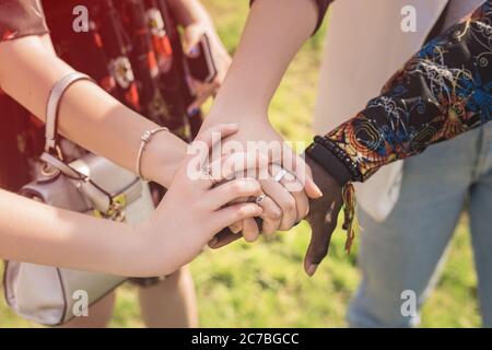 Nahaufnahme der Ansicht von oben, dass junge Menschen mit unterschiedlichen Nationalitäten die Hände zusammenlegen. Stapel von Freunden Hände. Stockfoto