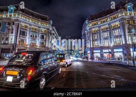 London, Großbritannien. Ca. August 2017. Schwarzes Londoner Taxi. Fußgänger und Verkehr in Oxford Circus bei Nacht Stockfoto