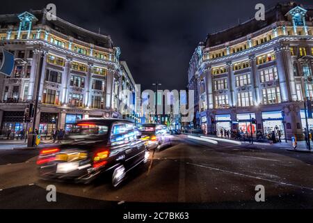 London, Großbritannien. Ca. August 2017. Schwarzes Londoner Taxi. Fußgänger und Verkehr in Oxford Circus bei Nacht Stockfoto