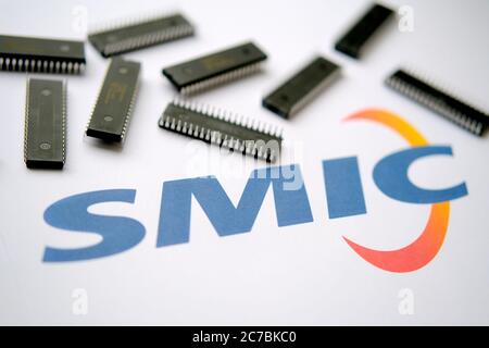 Stone / UK - 8. Juli 2020: SMIC-Logo auf dem Papierdokument und große Mikrochips, die herum platziert sind. Illustration für Hersteller von elektronischen Chips. Stockfoto