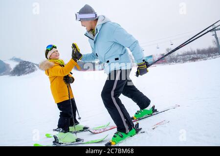 Ski rutschig Schnee Hand-klatschen glücklichen Vater und Sohn Stockfoto