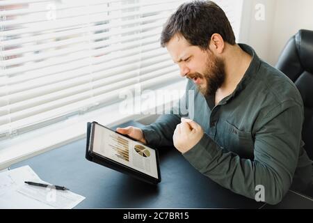 Männliche erfolgreiche Broker arbeiten mit Grafiken und Diagramme auf Tablette. Stockfoto