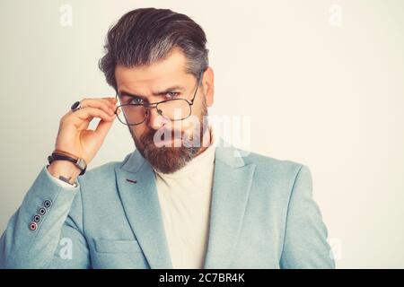 Erfolgreicher junger Geschäftsmann in klassischem blauen Anzug posiert isoliert auf weißem Wandhintergrund. Stockfoto