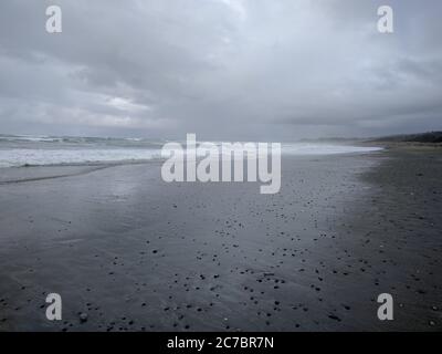 Breite Aufnahme eines Strandes in British Columbia, Kanada während bedeckt, Steine entlang des Strandes verstreut Stockfoto