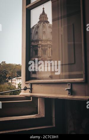 Graustufenaufnahme eines alten geöffneten Holzfensters mit dem Spiegelung einer Kuppel Stockfoto