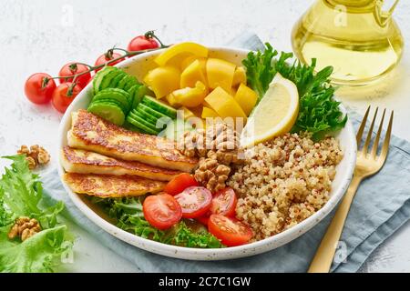 Buddha Schüssel mit Halloumi, Salatsalat, Quinoa, ausgewogenes Essen, weißer Hintergrund, Nahaufnahme Stockfoto