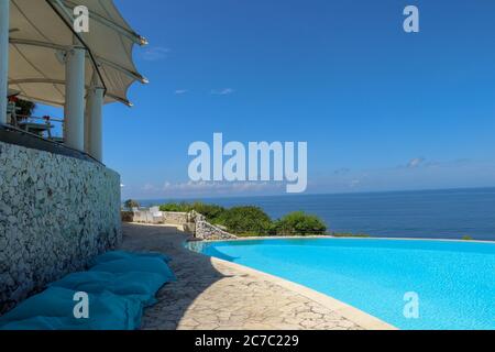 Luxuriöser Infinity-Pool mit Meerblick und Palmen. Bali, Indonesien Stockfoto