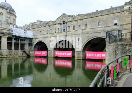 Bath, 16. Juli 2020. Die Demonstranten des Klimawandels Aussterben Rebellion hat unter den Bögen der historischen Pulteney-Brücke am Fluss Avon in Bath Banner angebracht. Die Botschaft ist, dass wir nach der Corona Virus Pandemie in einer grünen Weise, die für die Umwelt sympathisch ist, wieder aufbauen sollten. Kredit: JMF Nachrichten/Alamy Live Nachrichten Stockfoto