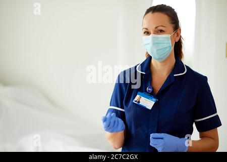 Krankenschwester, die mit dem Patienten spricht und die PSA trägt Stockfoto