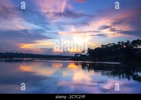 Sonnenuntergang Blick auf den Victoria Nil Fluss, mit Bäumen wachsen und die Reflexionen auf dem Wasser, Jinja, Uganda, Afrika Stockfoto