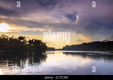 Sonnenuntergang Blick auf den Victoria Nil Fluss, mit Bäumen wachsen und die Reflexionen auf dem Wasser, Jinja, Uganda, Afrika Stockfoto