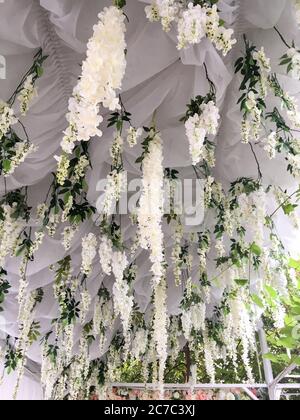 Niedriger Winkel Aufnahme von weißen Blumen, die von einer Decke hängen Aus Stoff Stockfoto